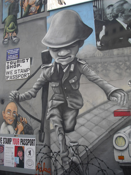 East Side Gallery - Berlin - Graffitis - Soldat springt über Stacheldrahtzaun